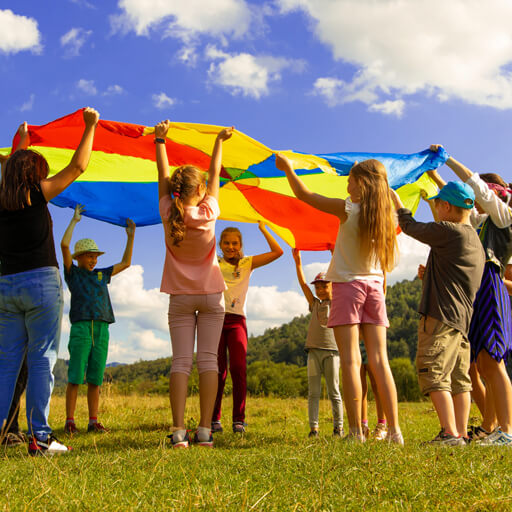 Children playing outside with a parachute game